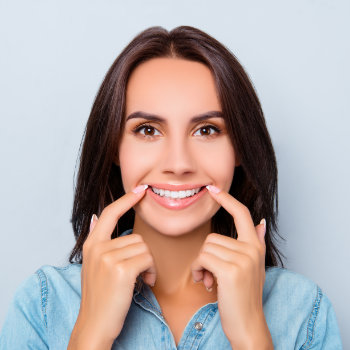 beautiful woman pointing to her healthy smile