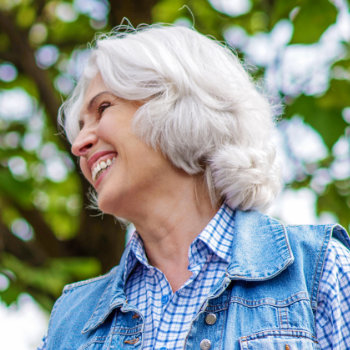 laughing elderly woman against the background of trees